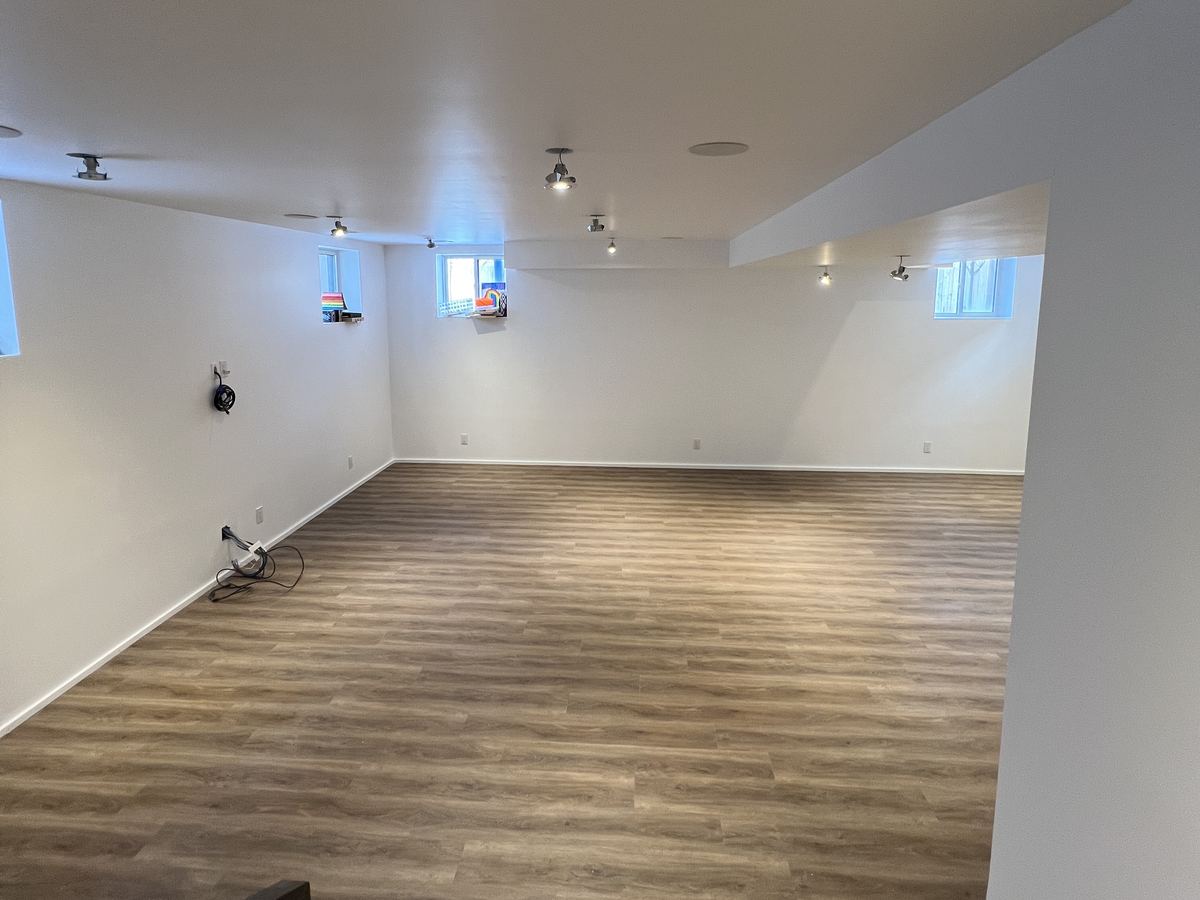 Basement rebuilt with new drywall, paint and vinyl plank flooring after water damage
